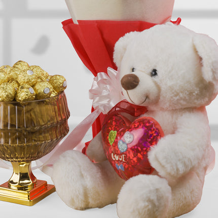 Valentine gift set with white teddy bear, heart cushion, red wrapped bouquet, and chocolates