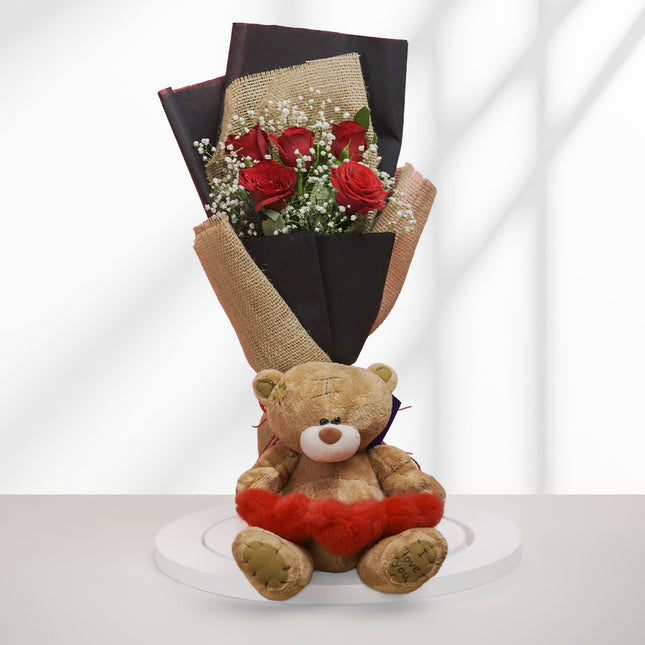 Bouquet of red roses with baby’s breath and a brown teddy bear holding a heart