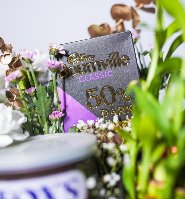 Cadbury Bournville Classic 50% dark chocolate bar among assorted flowers and plants