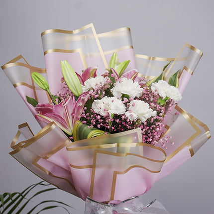 Elegant bouquet with pink lilies, white roses, pink baby’s breath, and gold-edged pink wrap