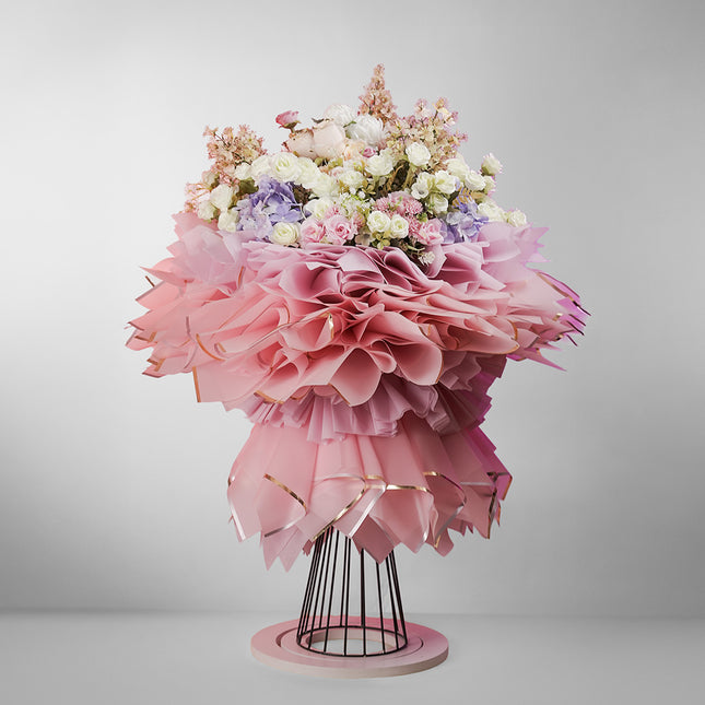 Luxury bouquet of pastel roses, peonies, hydrangeas in ruffled pink wrapping on stand