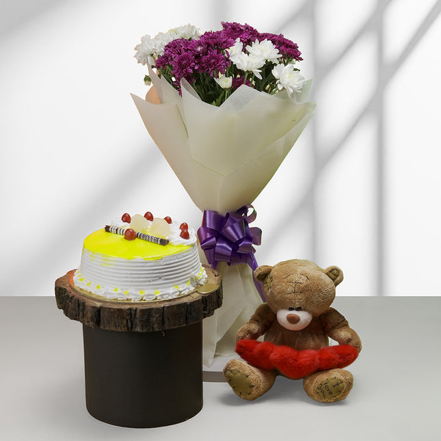 Bouquet of white and purple flowers, yellow cake, and teddy bear gift combo