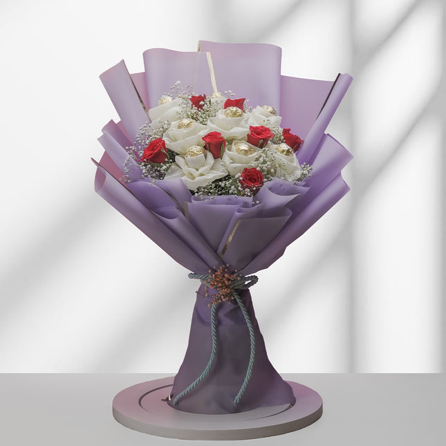 Ferrero Rocher bouquet with white and red roses wrapped in purple paper on white background