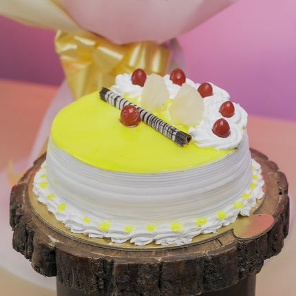 Yellow cream cake with cherries, chocolate sticks, and pineapple on wooden stand