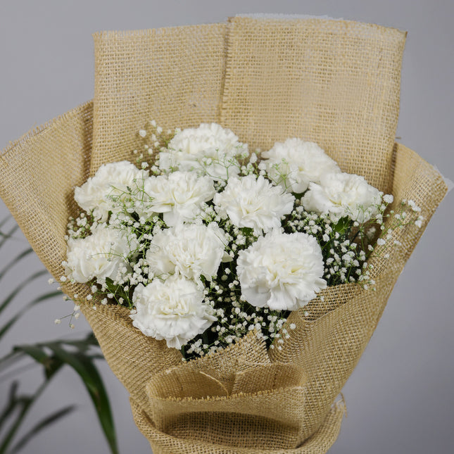 White carnation bouquet with baby's breath in burlap wrap, floral arrangement